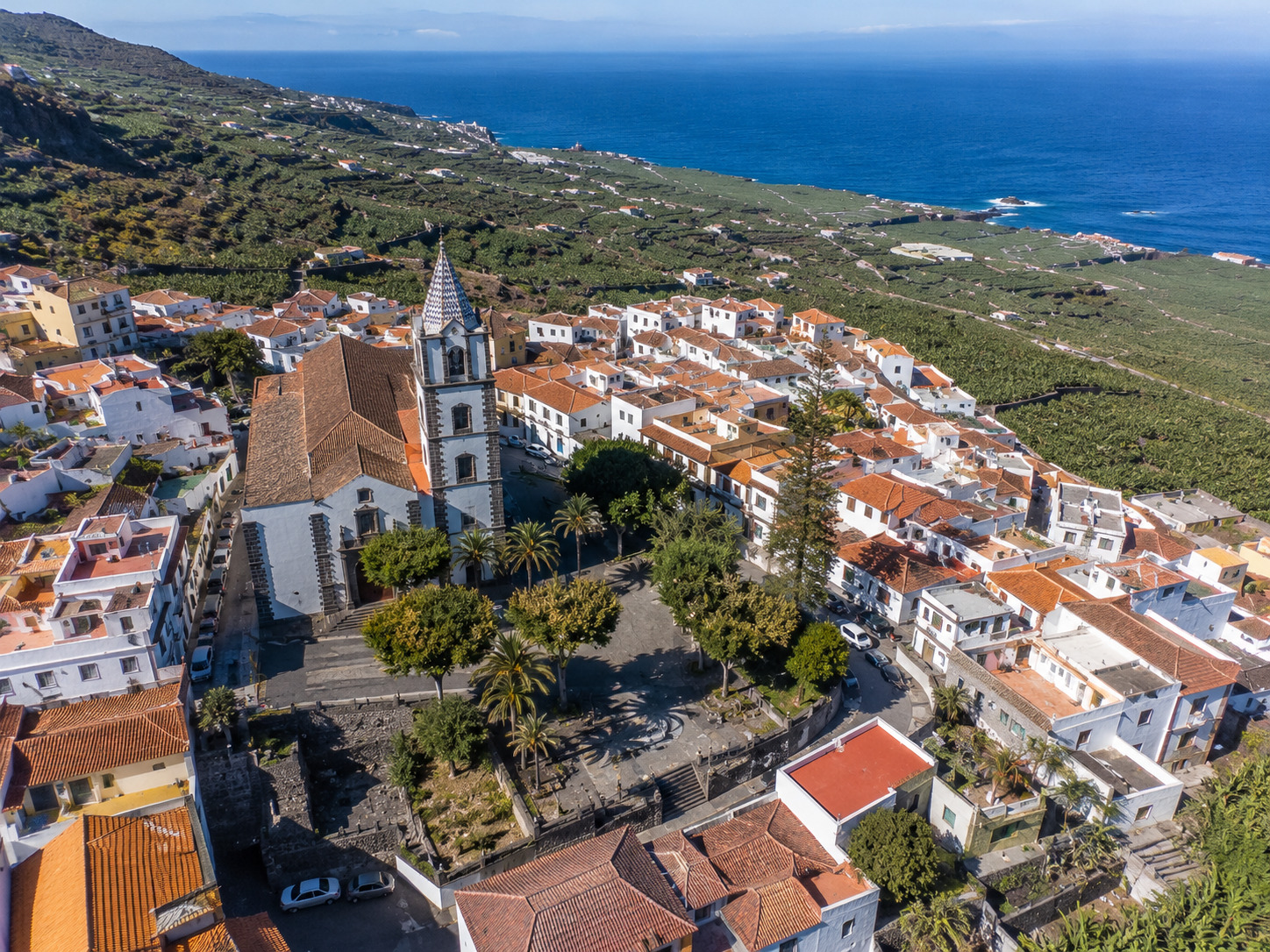 Guia de Isora pa Teneriffa – helikoptervy over den historiska staden med vitkalkade hus och bananodlingar mot Atlanten